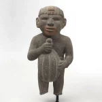 Mali kameni kip koji u svojim rukama drži kakao plod