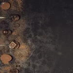 Šest kašika na kojima se nalaze različiti proizvodi od kakaoa na crnoj pozadini.