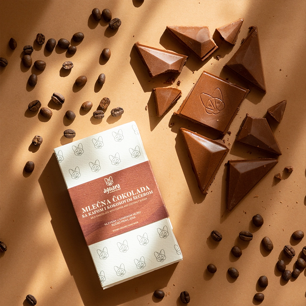 Aguara mlečna čokolada Zdravo sa kafom. Izlomljena čokolada, pakovanje i zrna kafe.