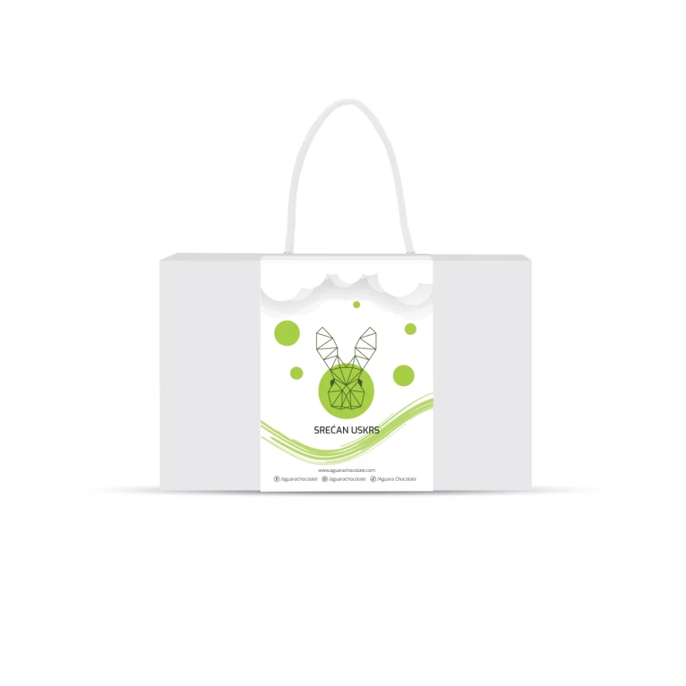 Srećan Uskrs poklon pakovanje Aguara chocolate. Bela kutija sa trakom koja ima kanap umesto drške. Na traci se nalazi linijski iscrtan zeka. Iznad njega se nalaze oblaci a ispod njega zakrivljene zelene linije. Oko zeke se nalaze zeleni krugovi .
